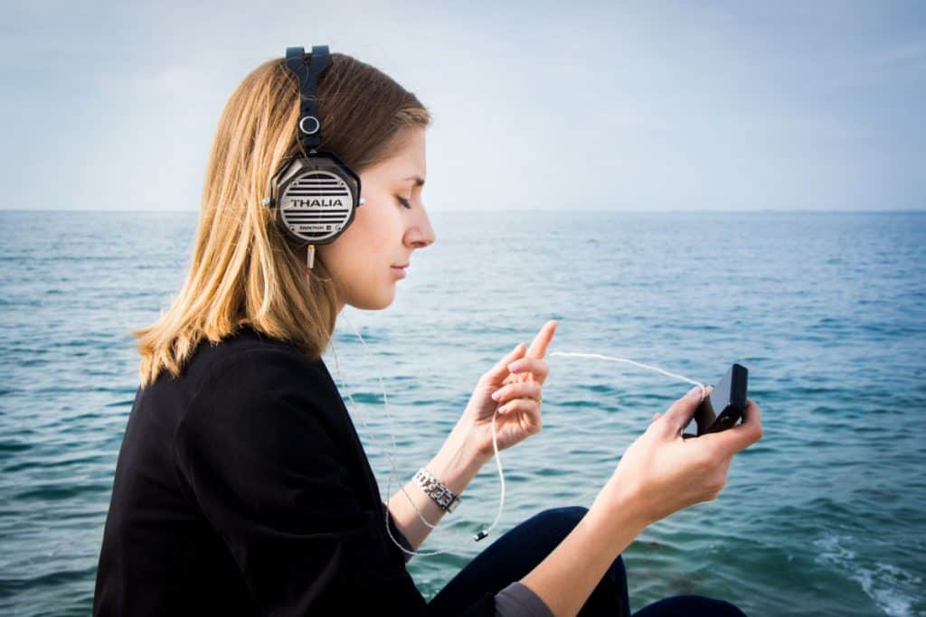 Woman listening to headphones at the sea