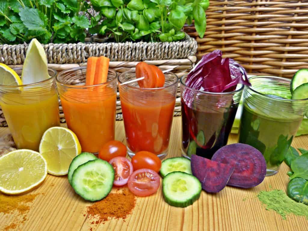 Various fruit and vegetables smoothies with spices and sliced fruits and vegetables