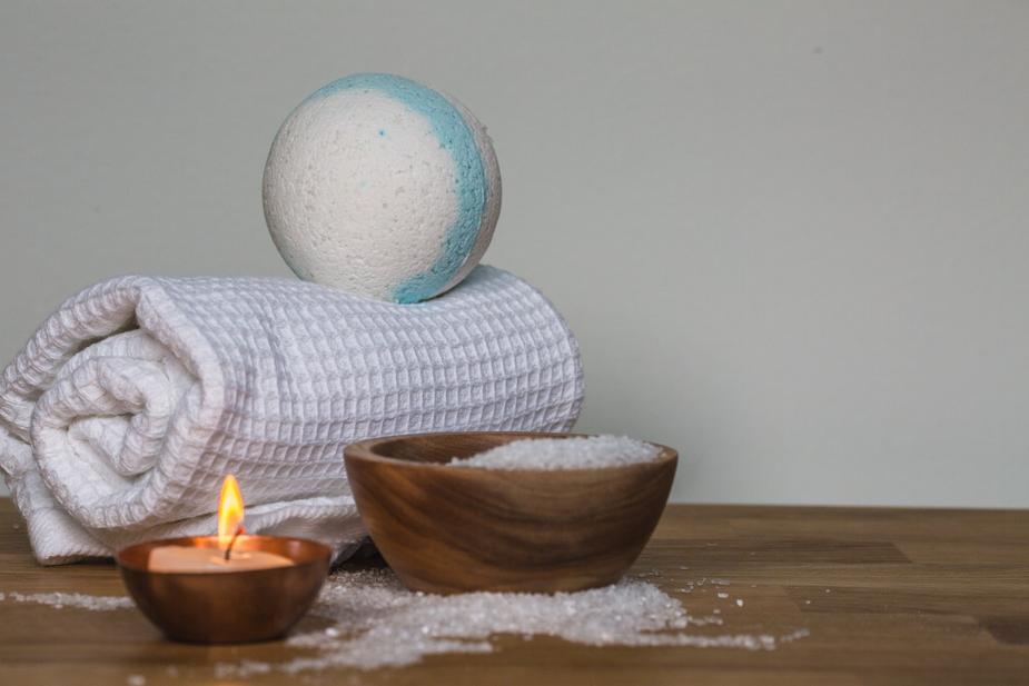 Bath salt in wooden casket with towel and candle