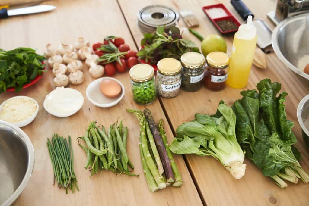 Various green vegetables and healthy foods on a wooden table