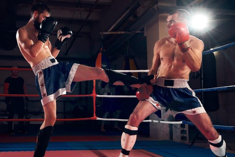 Kickboxer catching kick in ring