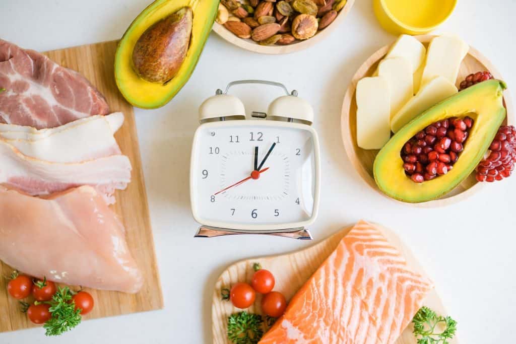 Analogue clock in the middle of various food plates